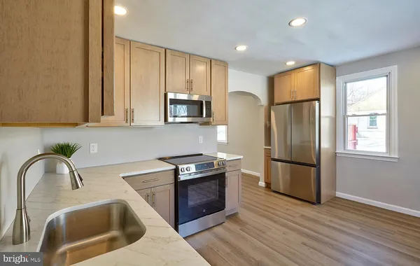 a kitchen with stainless steel appliances granite countertop a refrigerator a sink a stove a microwave a counter space and cabinets