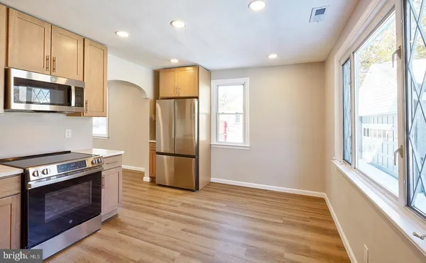 a kitchen with stainless steel appliances granite countertop a stove a refrigerator and a microwave