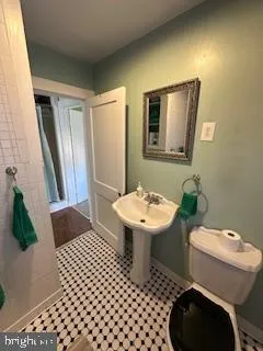 a bathroom with a sink a toilet a mirror and shower