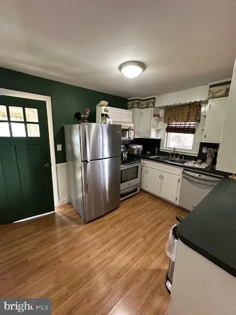 a kitchen with granite countertop a refrigerator stove and sink