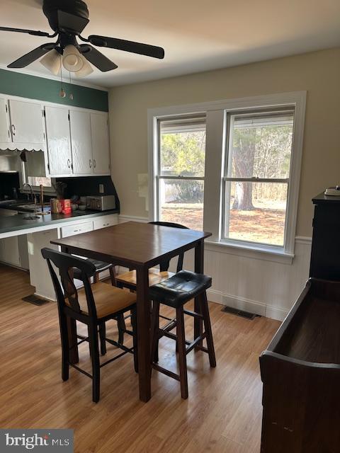 10116 Deal Island Road Deal Island, MD 21821 - Photo 9 of 30 a kitchen with stainless steel appliances granite countertop a stove a sink a microwave a dining table and chairs with wooden floor