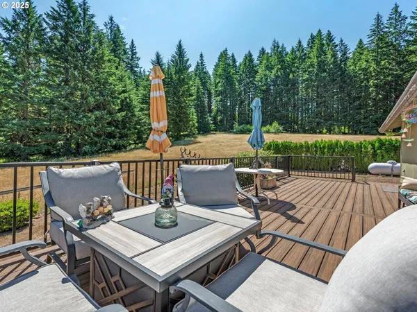 a view of a patio with table and chairs a barbeque with wooden floor and fence