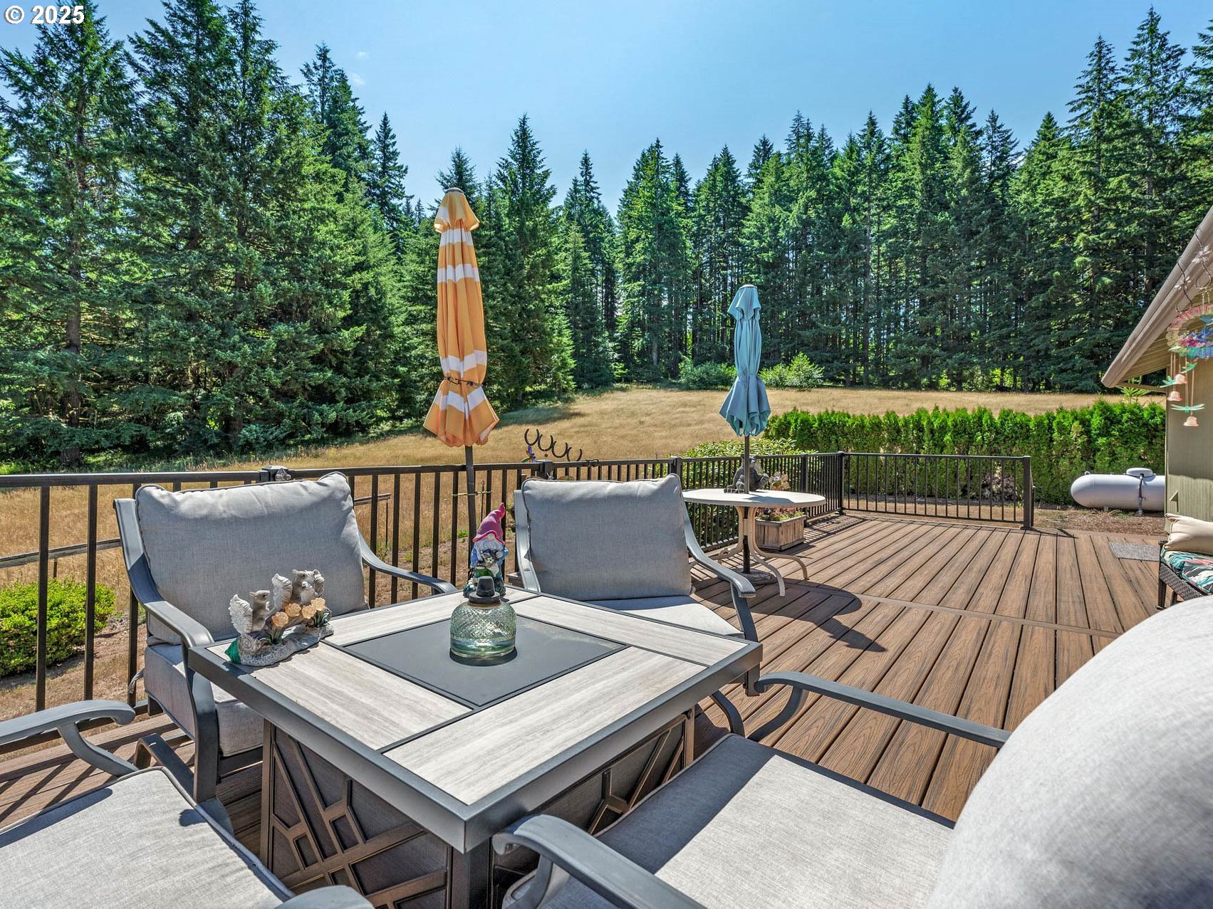 25420 Northwest Pumpkin Ridge Road North Plains, OR 97133 - Photo 15 of 41 a view of a patio with table and chairs a barbeque with wooden floor and fence