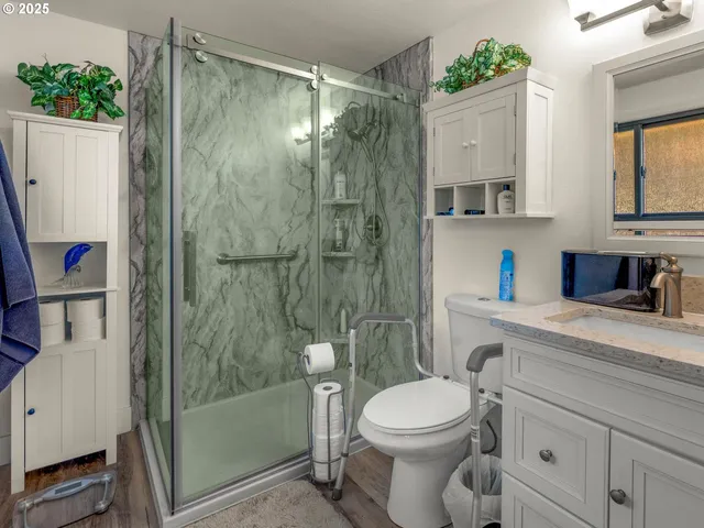 a bathroom with a sink a toilet and shower