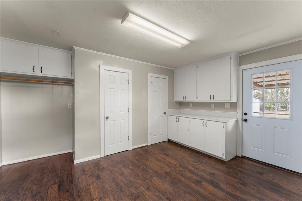 714 Jeanell Street Quitman, TX 75783 - Photo 9 of 20 a view of a kitchen with wooden floor and white cabinets