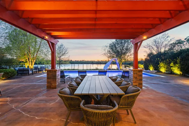 a view of a white house that has a big yard and large trees
