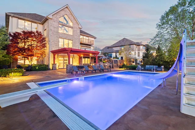 an outdoor space with chairs pool and furniture