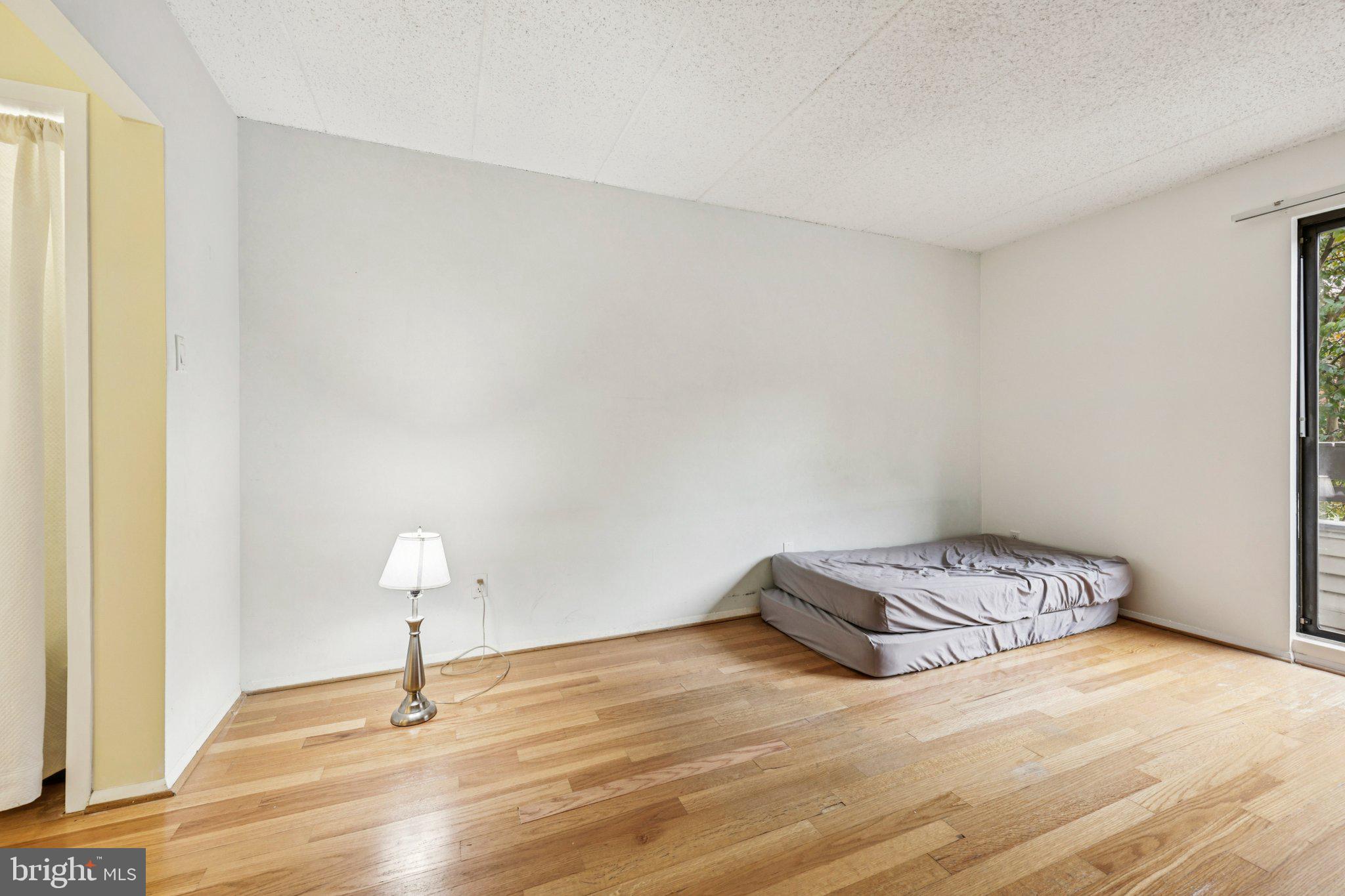 2118 Green Watch Way, Unit 10/201C Reston, VA 20191 - Photo 15 of 30 a view of bedroom with a bed and a lamp