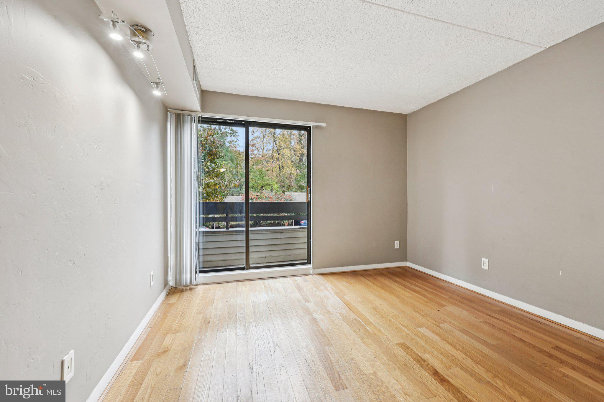 2118 Green Watch Way, Unit 10/201C Reston, VA 20191 - Photo 18 of 30 an empty room with wooden floor and windows
