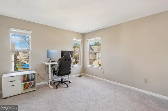 a view of a workspace with furniture and a window
