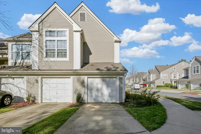 a front view of a house with a garden and garage