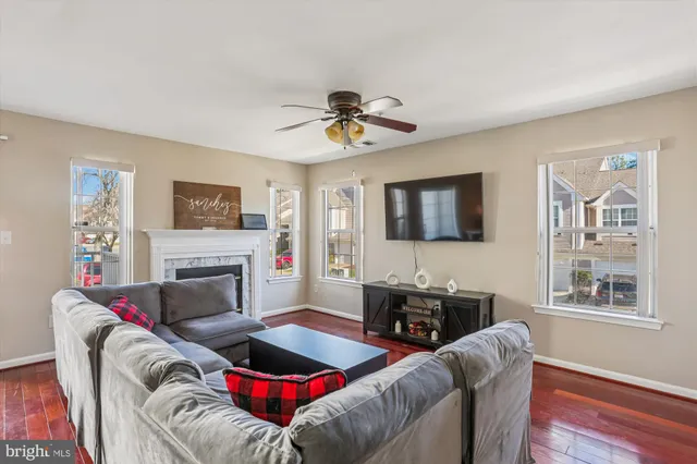 a living room with furniture a flat screen tv and a fireplace