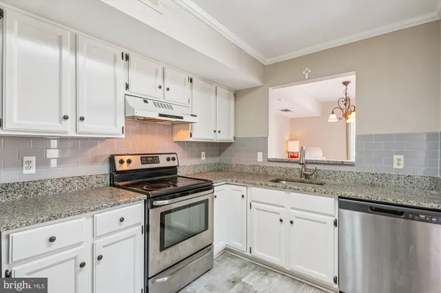 a kitchen with granite countertop white cabinets white stainless steel appliances and white cabinets