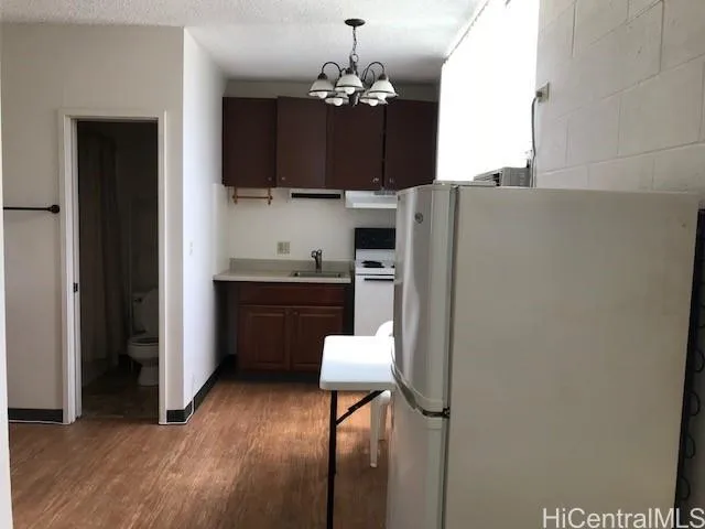 a kitchen with stainless steel appliances a refrigerator and a chandelier