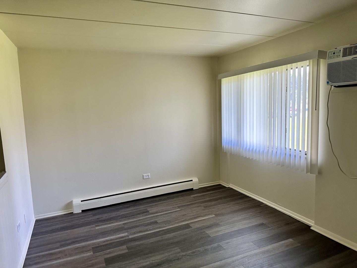 250 North Entrance Avenue, Unit 4B Kankakee, IL 60901 - Photo 2 of 6 an empty room with wooden floor and windows with curtains