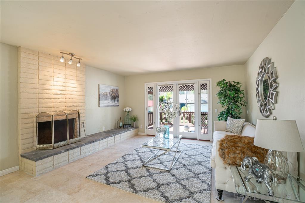 2506 Windmill View Road El Cajon, CA 92020 - Photo 9 of 25 THE FORMAL LIVING ROOM WITH DECORATIVE FIREPLACE AND AN ENTRANCE TO A FRONT PATIO WITH ZEN WATER FEATURE.