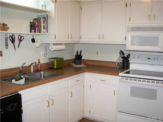 641 Pine Ridge Place Raleigh, NC 27609 - Photo 12 of 25 a kitchen with white cabinets and white appliances