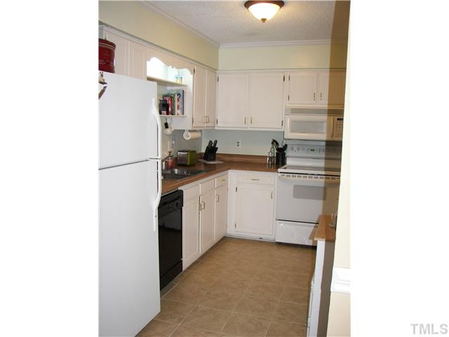 641 Pine Ridge Place Raleigh, NC 27609 - Photo 13 of 25 a kitchen with a sink a refrigerator and cabinets