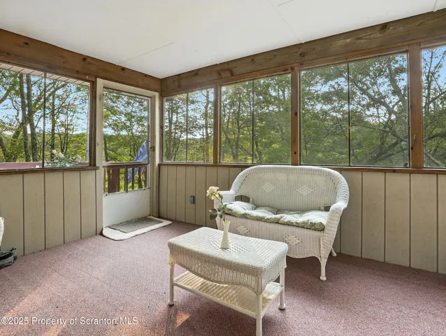 a living room with furniture and a floor to ceiling window