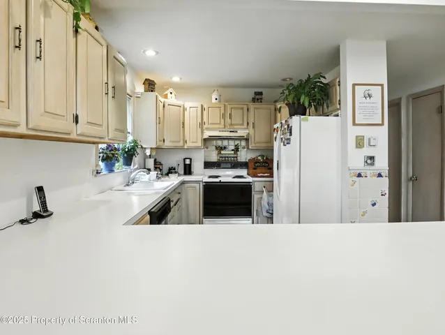 a kitchen with refrigerator a sink a stove and cabinets