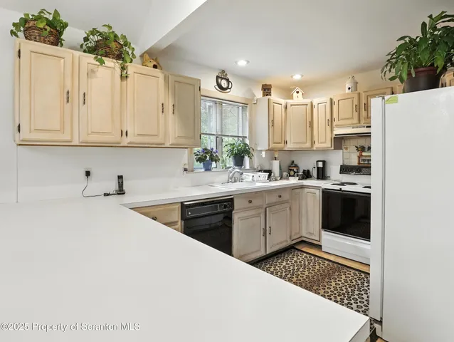 a kitchen with kitchen island granite countertop a white cabinets and white appliances