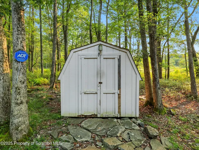 a backyard of a house with fountain plants and large trees
