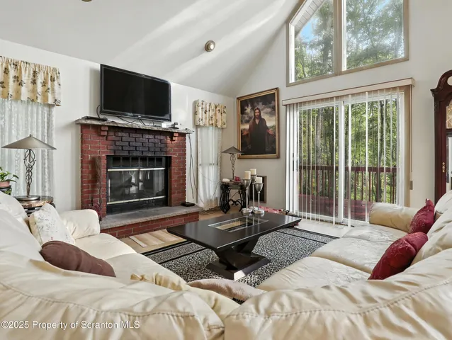 a bedroom with a bed a flat screen tv and a fireplace