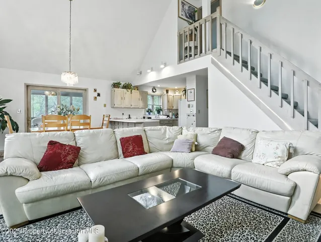 a living room with furniture kitchen view and a chandelier