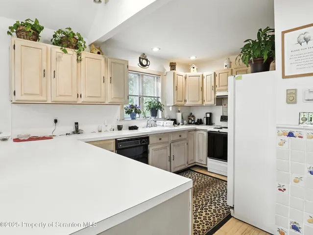 a kitchen with a sink a refrigerator and white cabinets
