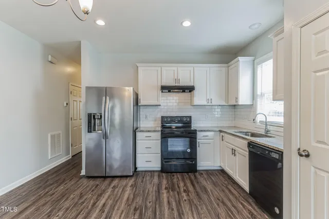 a kitchen with stainless steel appliances granite countertop a stove a sink and a refrigerator
