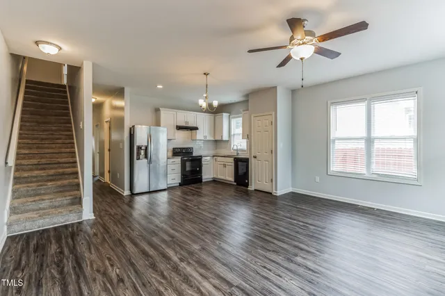 a view of a kitchen with a fridge wooden floor and a ceiling fan