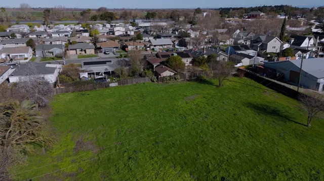 an aerial view of residential houses with outdoor space and river