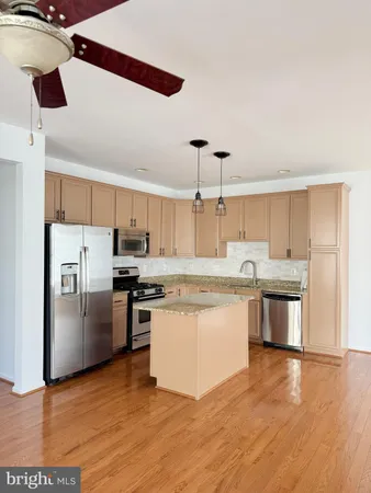 a kitchen with stainless steel appliances a sink a stove a refrigerator and island