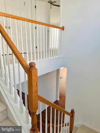 a view of staircase with railing and white walls