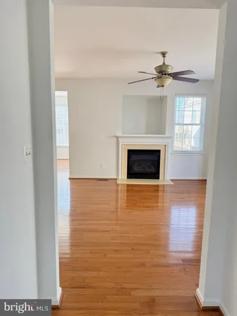 a view of an empty room with a fireplace and a window