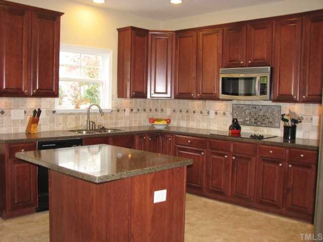 125 Locke Woods Road Raleigh, NC 27603 - Photo 2 of 12 You will be impressed by the gourmet kitchen. Features include a tile back splash, granite, work island, stainless steel double ovens and microwave, and huge walk in pantry.