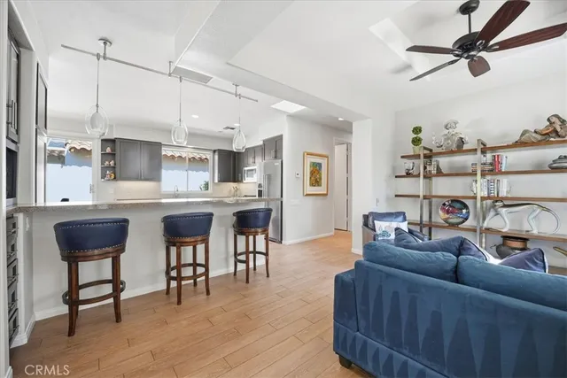 a living room with furniture kitchen view and a wooden floor