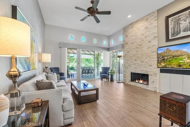 a living room with furniture a fireplace and a floor to ceiling window