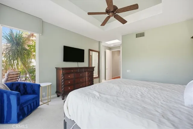 a bedroom with a bed a couch and a flat screen tv