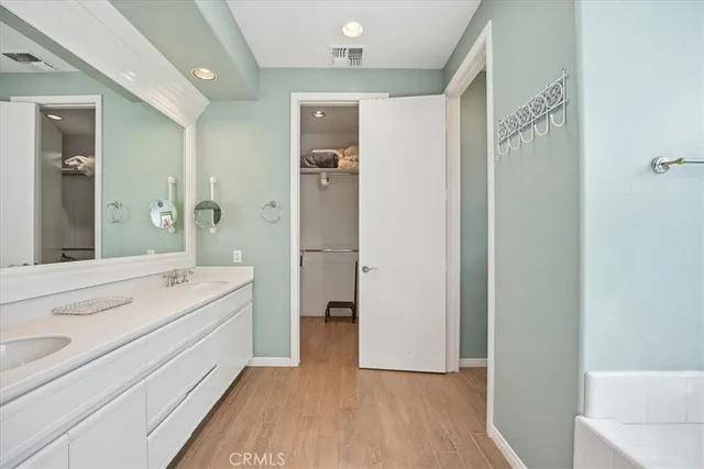 a spacious bathroom with a double vanity sink a mirror and a shower