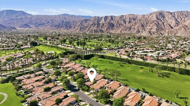 an aerial view of a city with lots of residential buildings ocean and mountain view in back