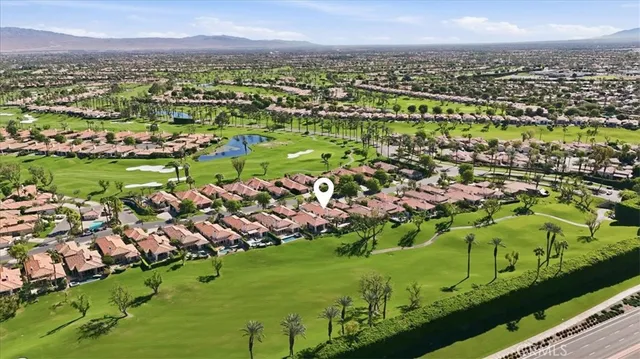 an aerial view of a house with a garden and mountains
