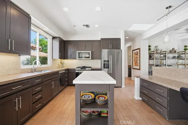 a kitchen with stainless steel appliances granite countertop a sink stove and refrigerator