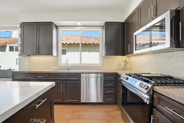 a kitchen with stainless steel appliances granite countertop a sink stove and cabinets