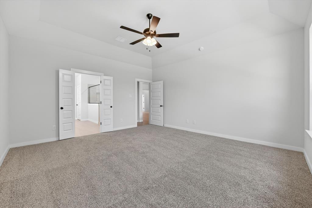 409 Mcalpine Springtown, TX 76082 - Photo 20 of 38 Spacious room featuring vaulted ceilings, neutral-toned carpet flooring, and white walls