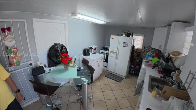 a view of a dining room with furniture and a refrigerator