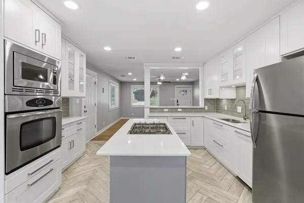 a kitchen with stainless steel appliances granite countertop a refrigerator stove microwave and sink