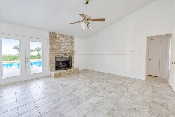 an empty room with windows and fireplace