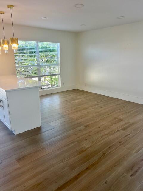 727 Hummingbird Way, Unit 1 North Palm Beach, FL 33408 - Photo 4 of 13 a view of an empty room and wooden floor and a window