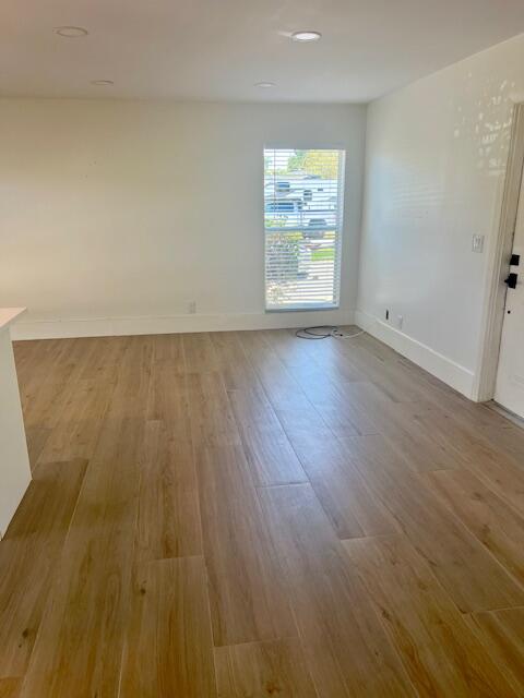 727 Hummingbird Way, Unit 1 North Palm Beach, FL 33408 - Photo 5 of 13 an empty room with wooden floor and windows